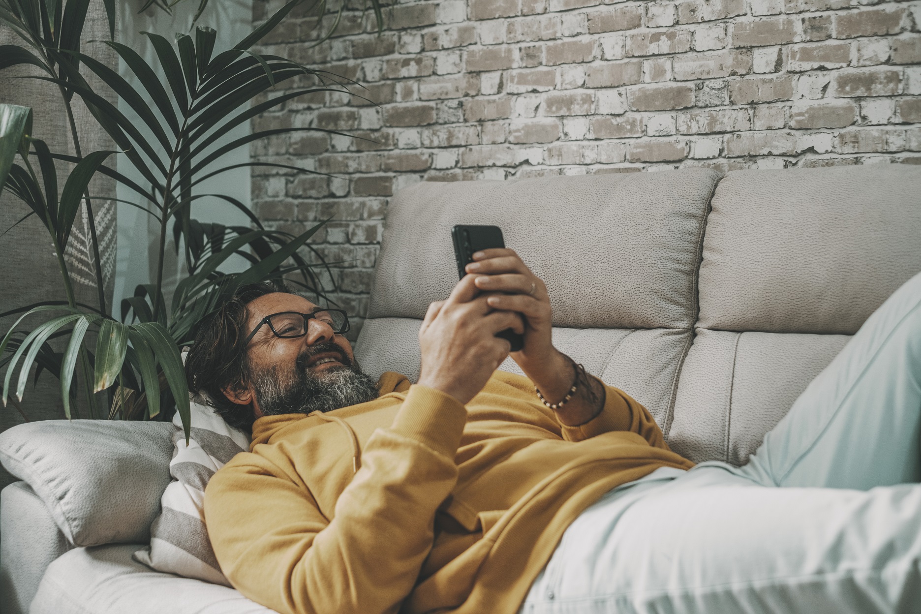 one mature man use mobile phone cellular laying on y6bwp8s.jpg